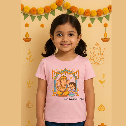 pink t-shirt with a Ganesha and child illustration, standing against a decorated background.