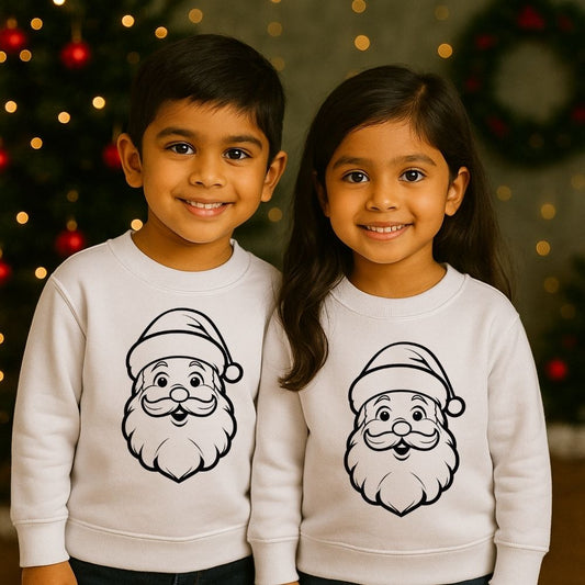 Two children wearing white sweatshirts with Santa Claus faces