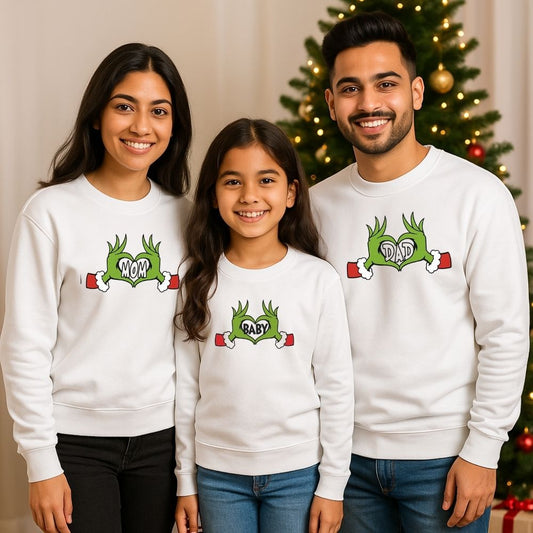 White Family of three wearing matching white sweatshirts with festive designs