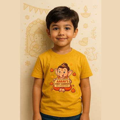 a yellow t-shirt with a cartoon character and text, standing against a decorated wall.