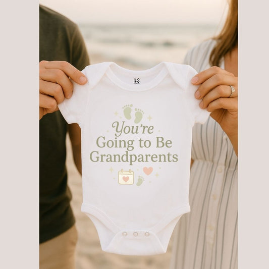 White baby onesie with 'You're Going to Be Grandparents' text 