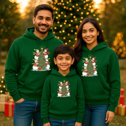Family of three wearing green hoodies with a Christmas tree design