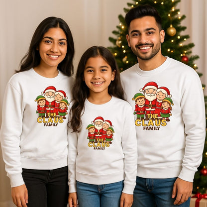 Family of three wearing matching Christmas-themed sweatshirts with 'The Claus Family' design White