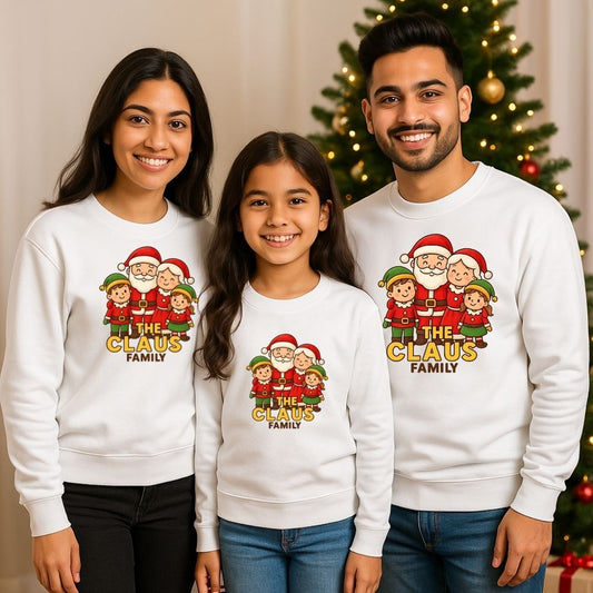 Family of three wearing matching Christmas-themed sweatshirts with 'The Claus Family' design White