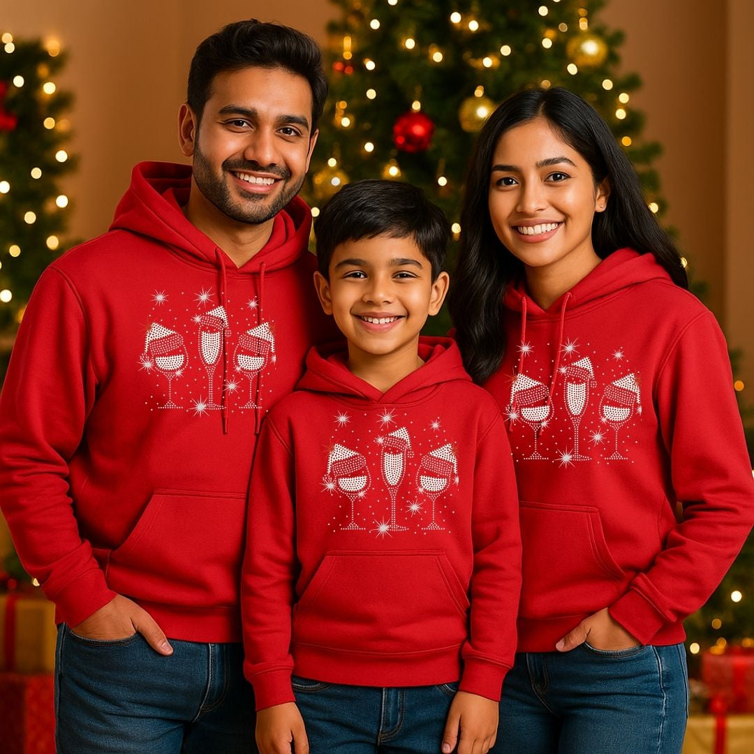 Family of three wearing red hoodies with a Christmas design