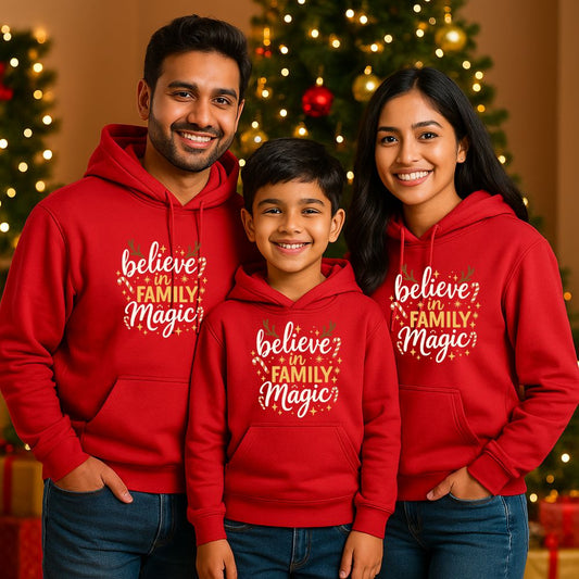Family of three wearing red hoodies with 'believe in FAMILY Magic' text