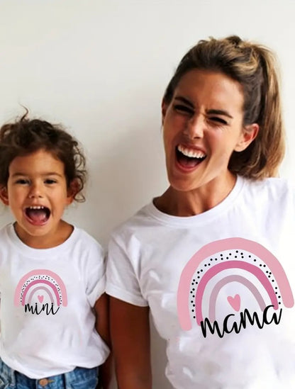A mother and daughter wearing matching white t-shirts with a rainbow and the word 'mama, mini' printed