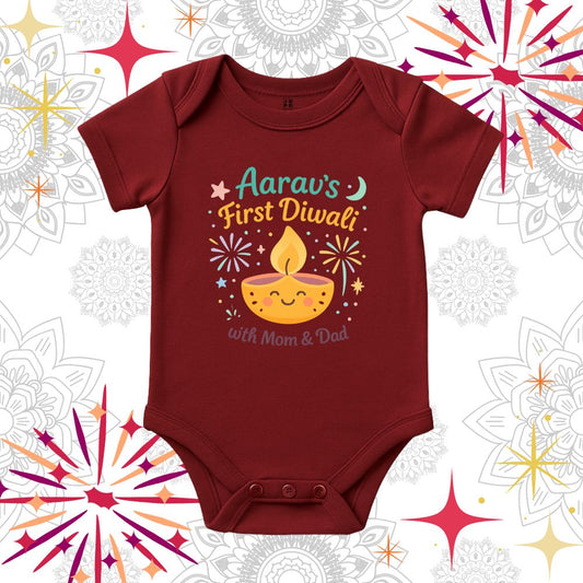 Maroon baby onesie with 'First Diwali with Mom & Dad' text and a smiling lamp design 