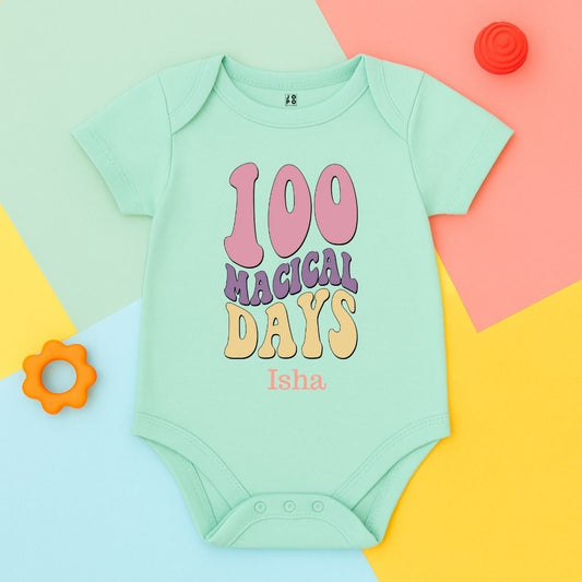 Mint green baby onesie with 100 Magical Days text