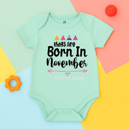 Mint green baby onesie with 'Kings are born in November' text 