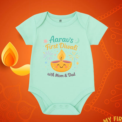 Mintgreen baby onesie with 'First Diwali with Mom & Dad' text and a smiling lamp design 