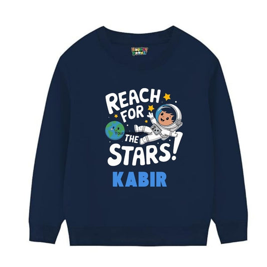 Navy blue kids' sweatshirt with a space theme design including the text 'REACH FOR THE STARS!' and the name 