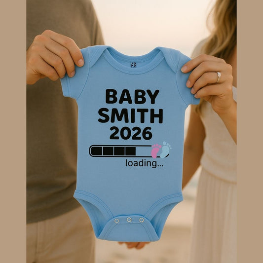Light blue baby onesie with 'BABY SMITH 2026 loading...' text and Baby Footprint with Loading Bar Graphic design
