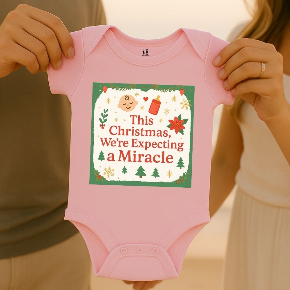 Pink baby onesie with "Thsi Christmas, We're Expecting a Miracle" text and feeding bottle and baby graphic design.