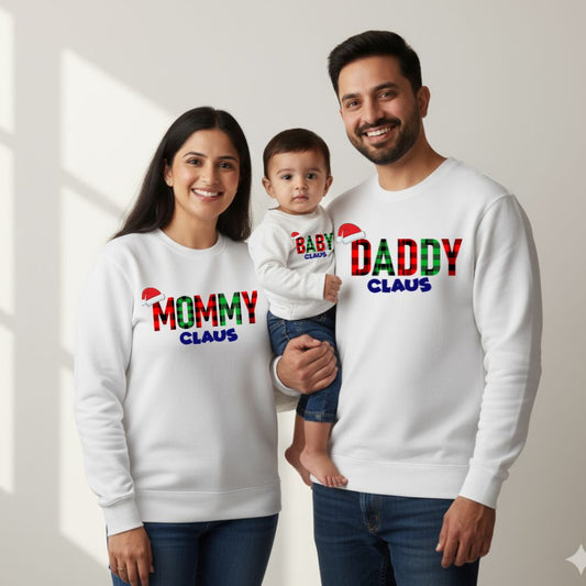 White Family of three wearing matching 'Mommy Claus', 'Baby Claus', and 'Daddy Claus' sweatshirts.