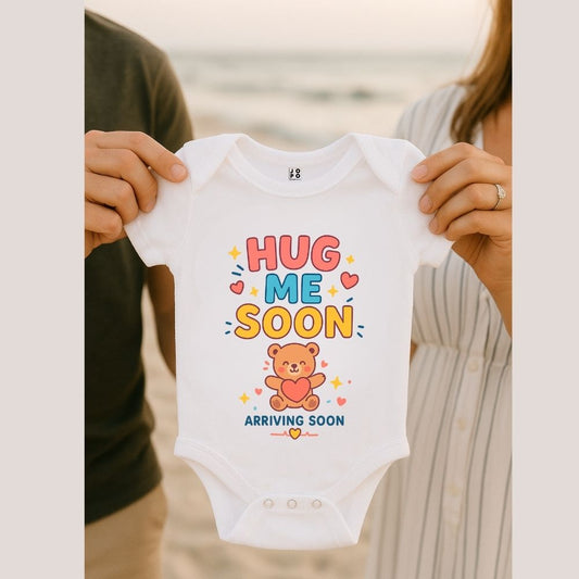 White baby onesie with "Hug me soon" colorful text and bear graphic 